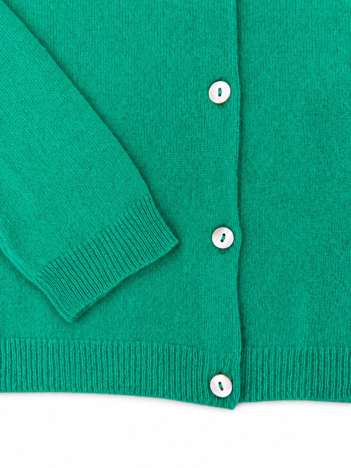 Close-up of the Balmoral green cashmere cardigan cuff, ribbed hem and pearl buttons.
