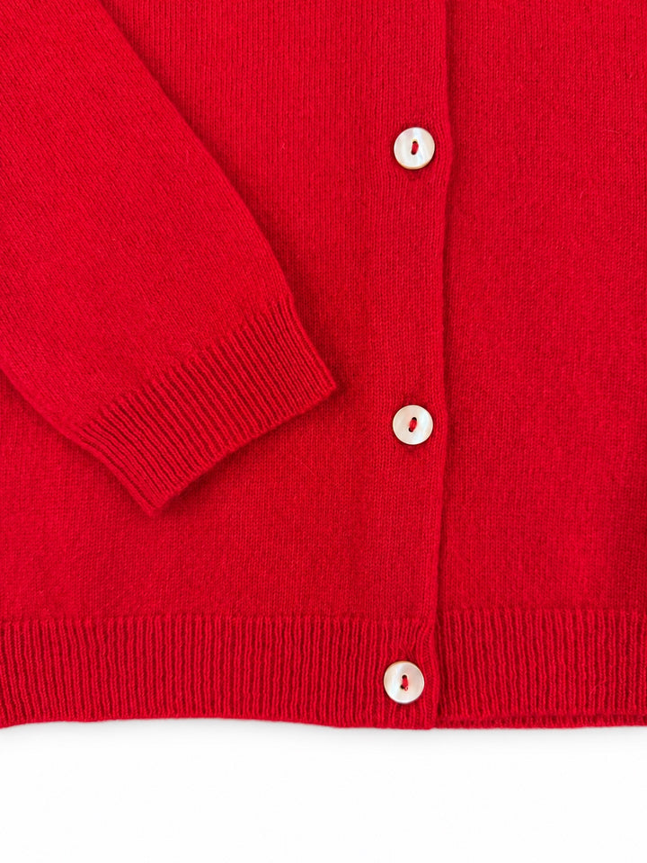 Close-up of the Balmoral red cashmere cardigan cuff, ribbed hem and pearl buttons.