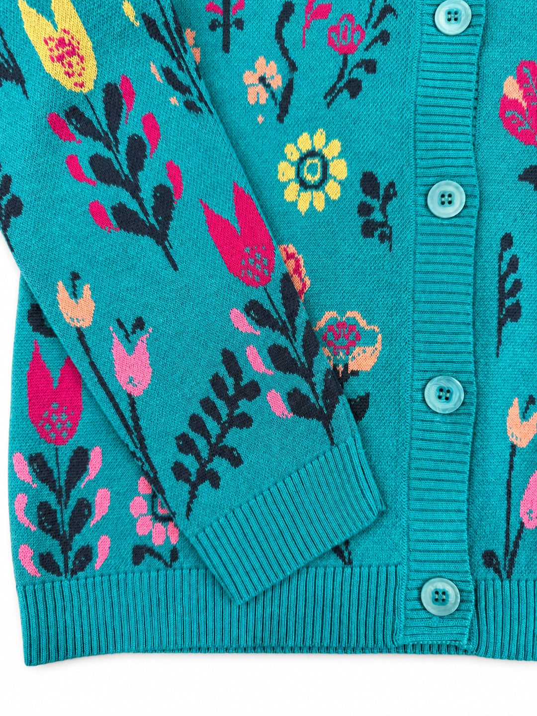 Close-up of the IVKO Wild Garden Adria jacquard jacket showing colourful floral wool knitting, turquoise buttons, ribbed cuff and hem.